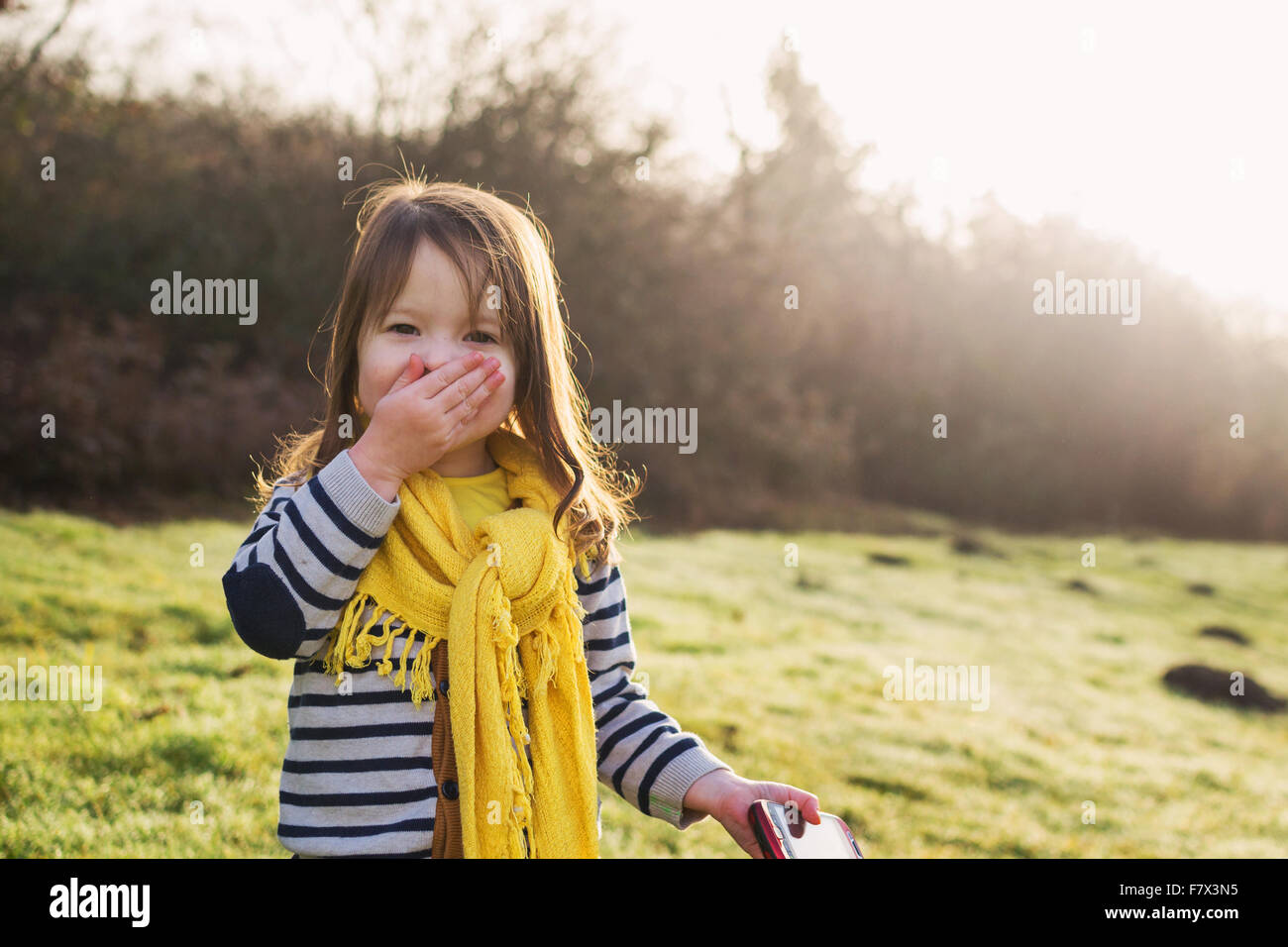 Mädchen mit Hand vor den Mund halten Handys lachen Stockfoto