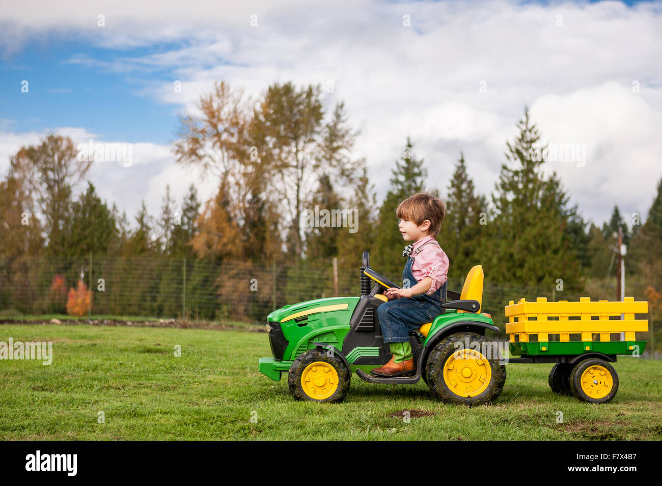 Junge, einen Spielzeug-Traktor fahren Stockfoto
