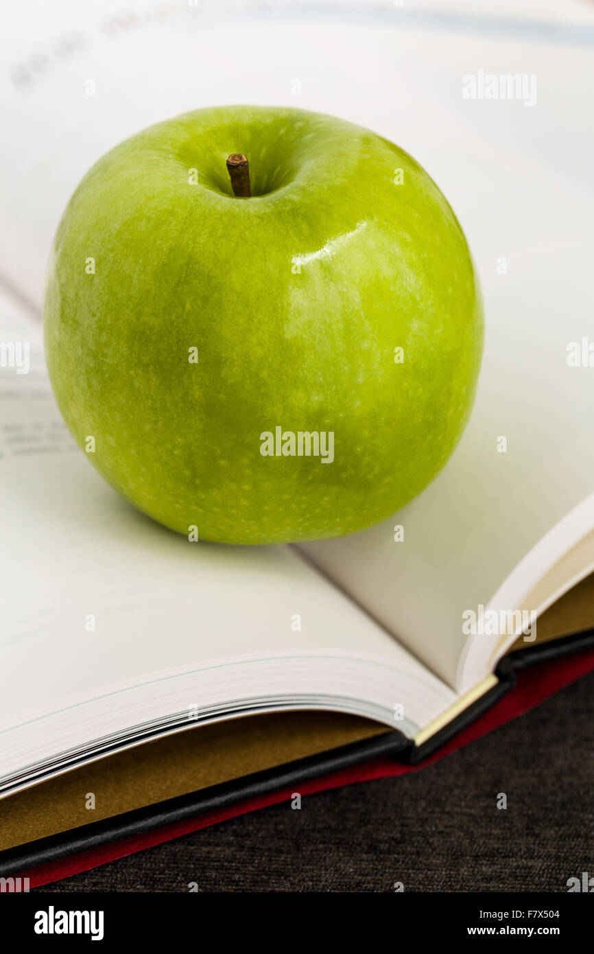 Grüner Apfel mit Buch illustriert wissen und Weisheit Konzept. Stockfoto