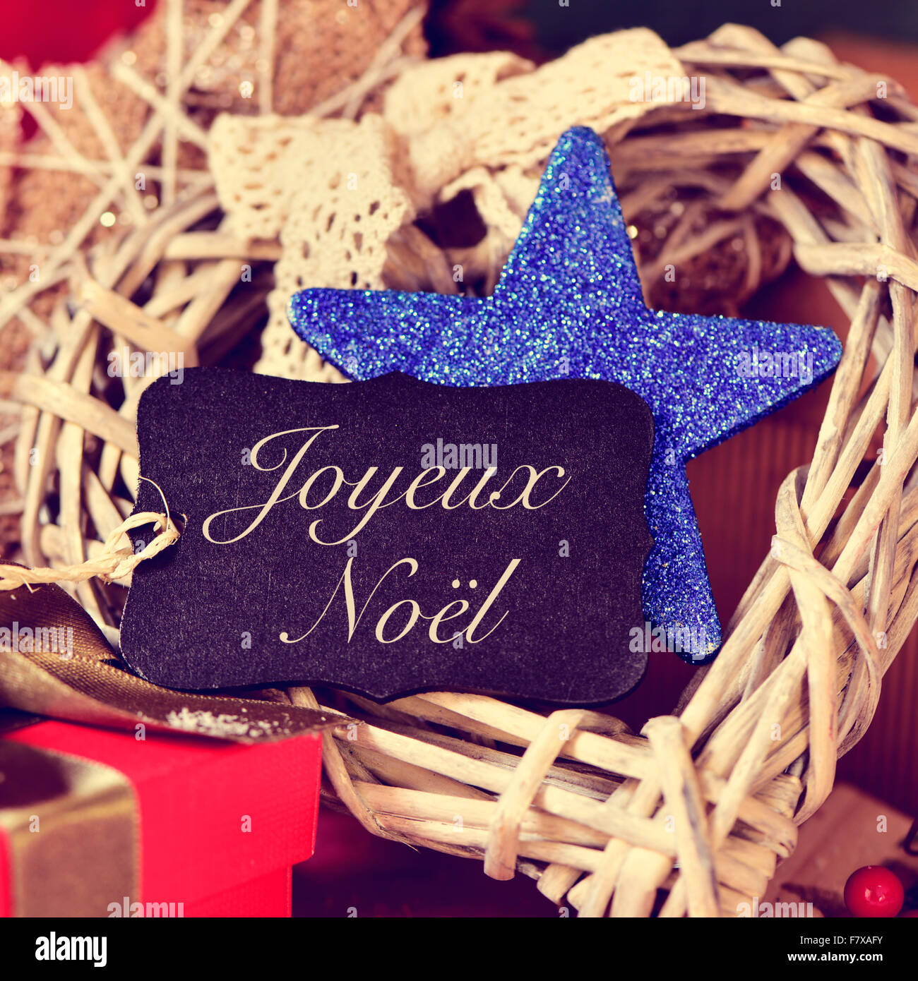 ein schwarzer Aufkleber mit Text Joyeux Noel, Frohe Weihnachten in Französisch, auf einen Haufen von Geschenken und anderen bonnie Christmas Ornamente Stockfoto