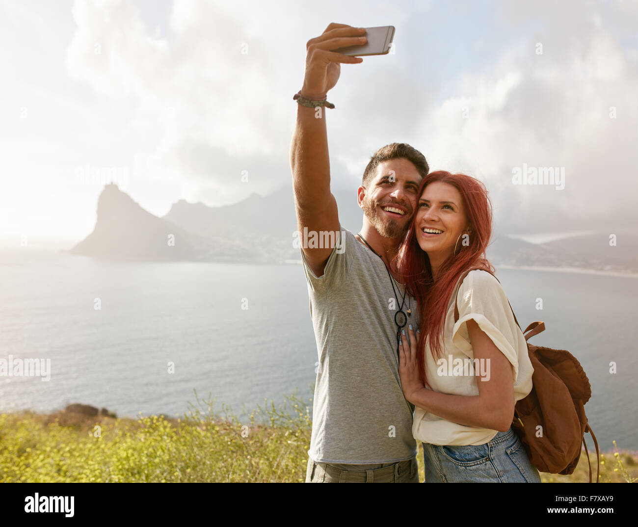 Fröhliches junges Paar auf Reisen machen Selfie mit Smartphone. Junges Paar an der Bucht unter einem Selfie Porträt mit Zelle pho Stockfoto