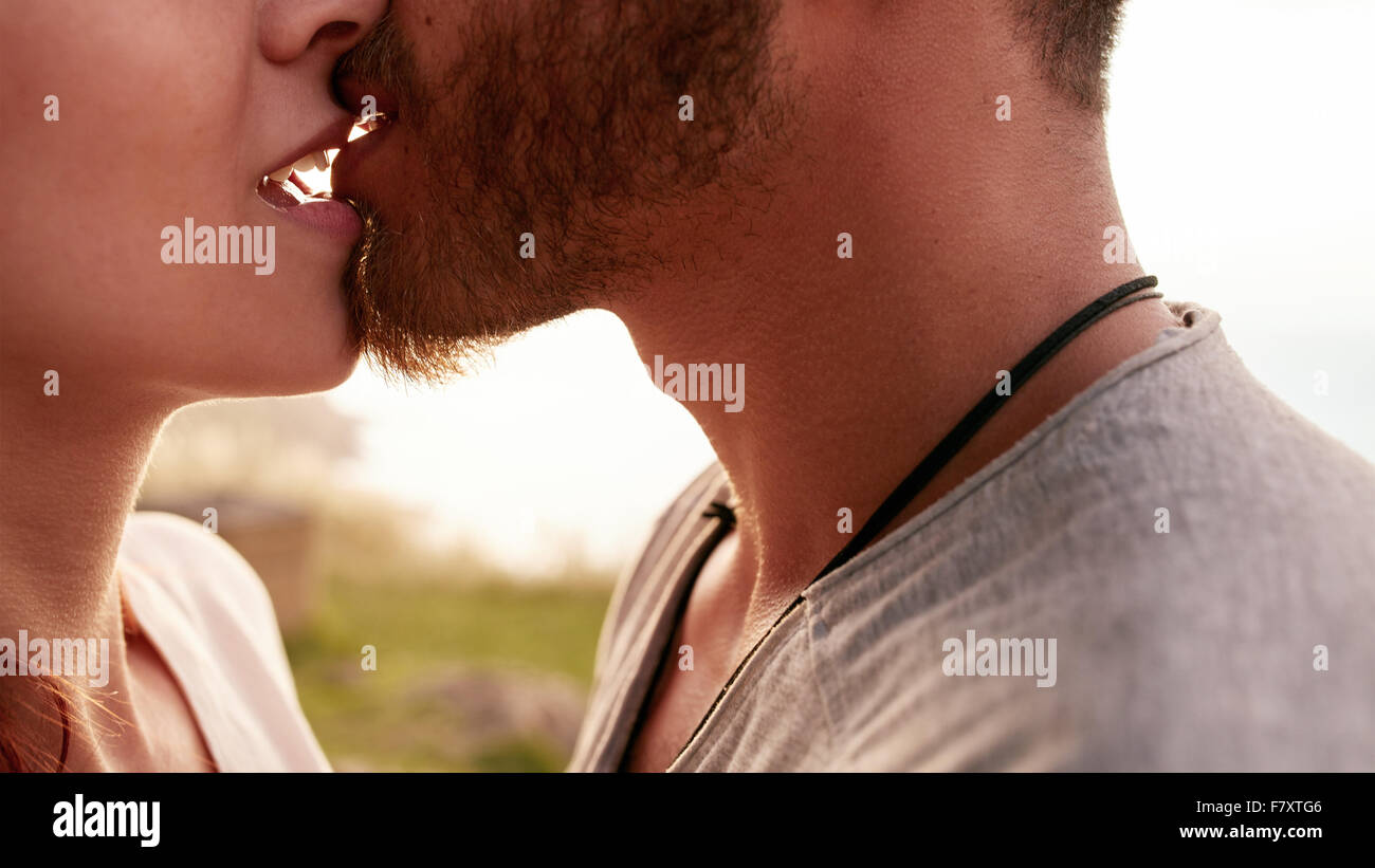 Schuss von zärtlich junge Paar küssen im freien hautnah. Der junge Mann und Frau in der Liebe beschnitten. Stockfoto