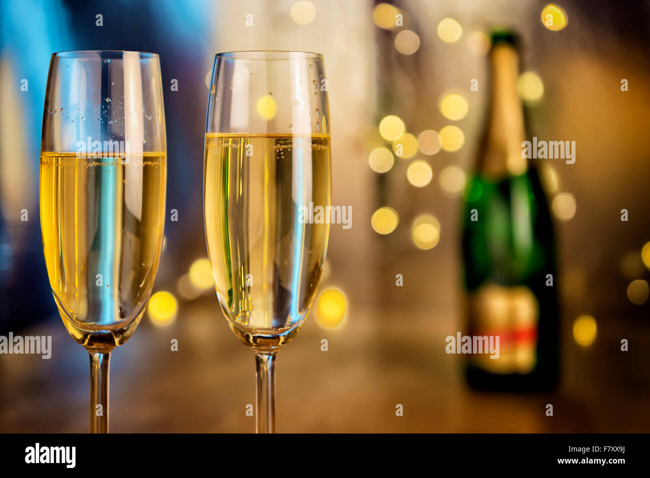 Bild von zwei Sektgläser mit Flasche und Unschärfe Lichter im Hintergrund Stockfoto