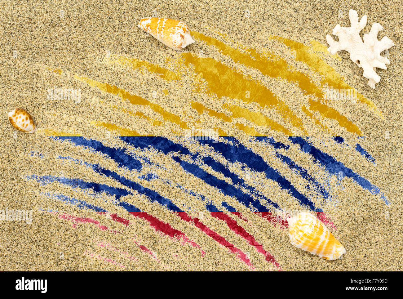 Nationale Flagge Kolumbiens unter einem Strand Hintergrund mit Sand, Muscheln und Korallen Stockfoto