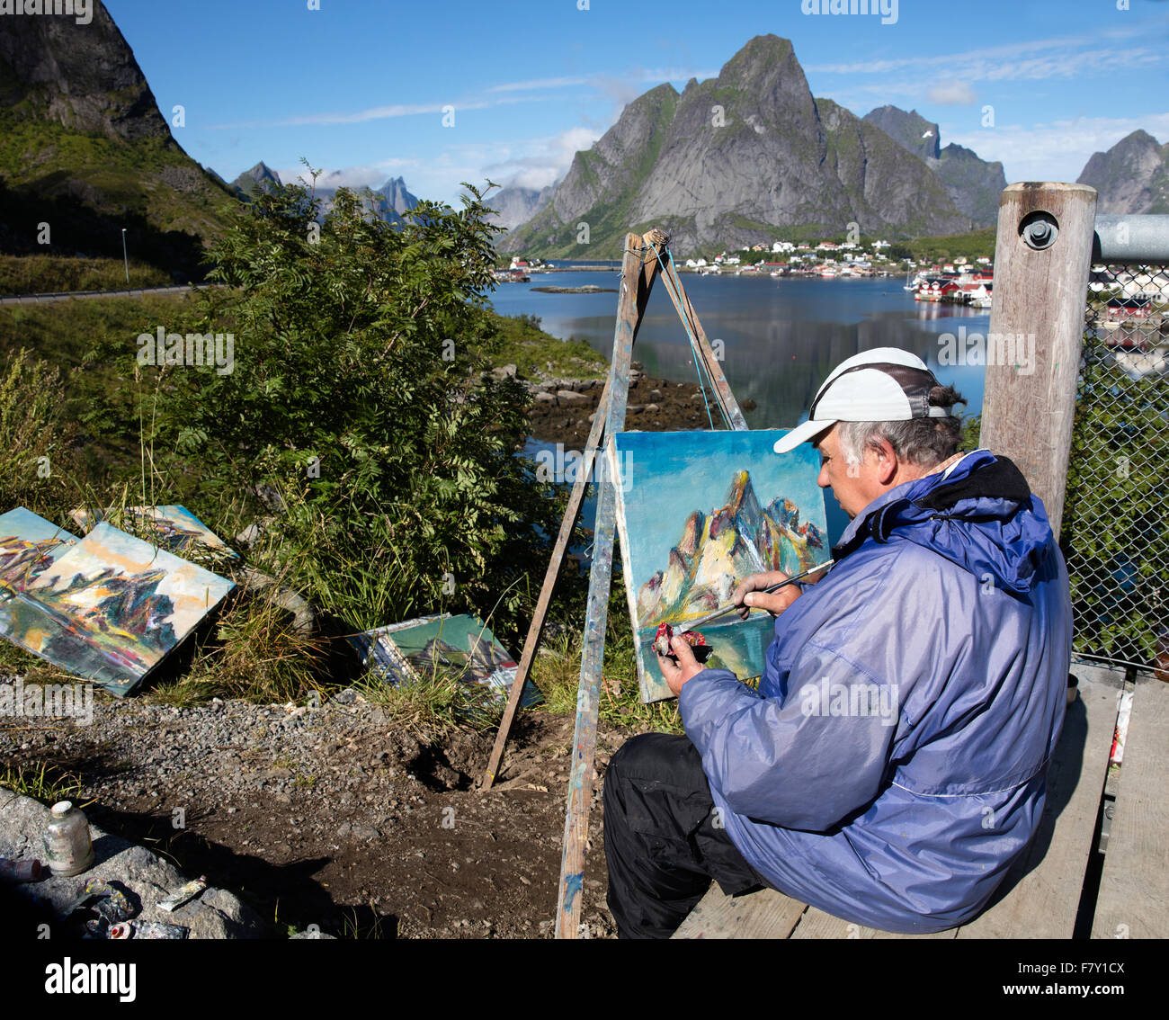 Ein Künstler mit seinen Bildern der Hafen Stadt der Reine und Olstinden Berg in th Lofoten-Inseln Norwegen Stockfoto