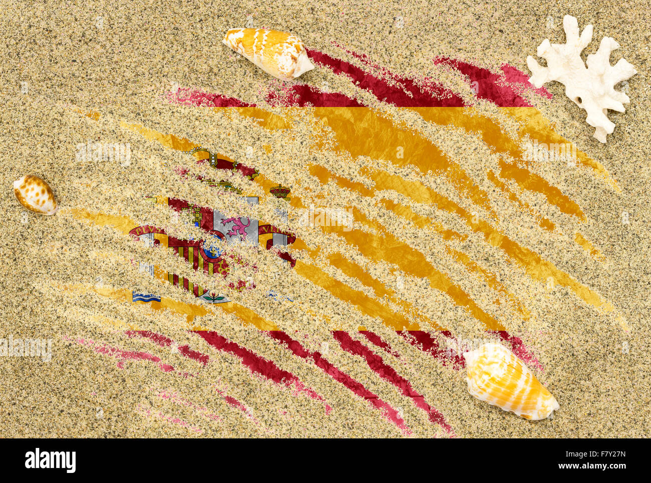 Nationale Flagge Spaniens unter einem Strand Hintergrund mit Sand, Muscheln und Korallen Stockfoto