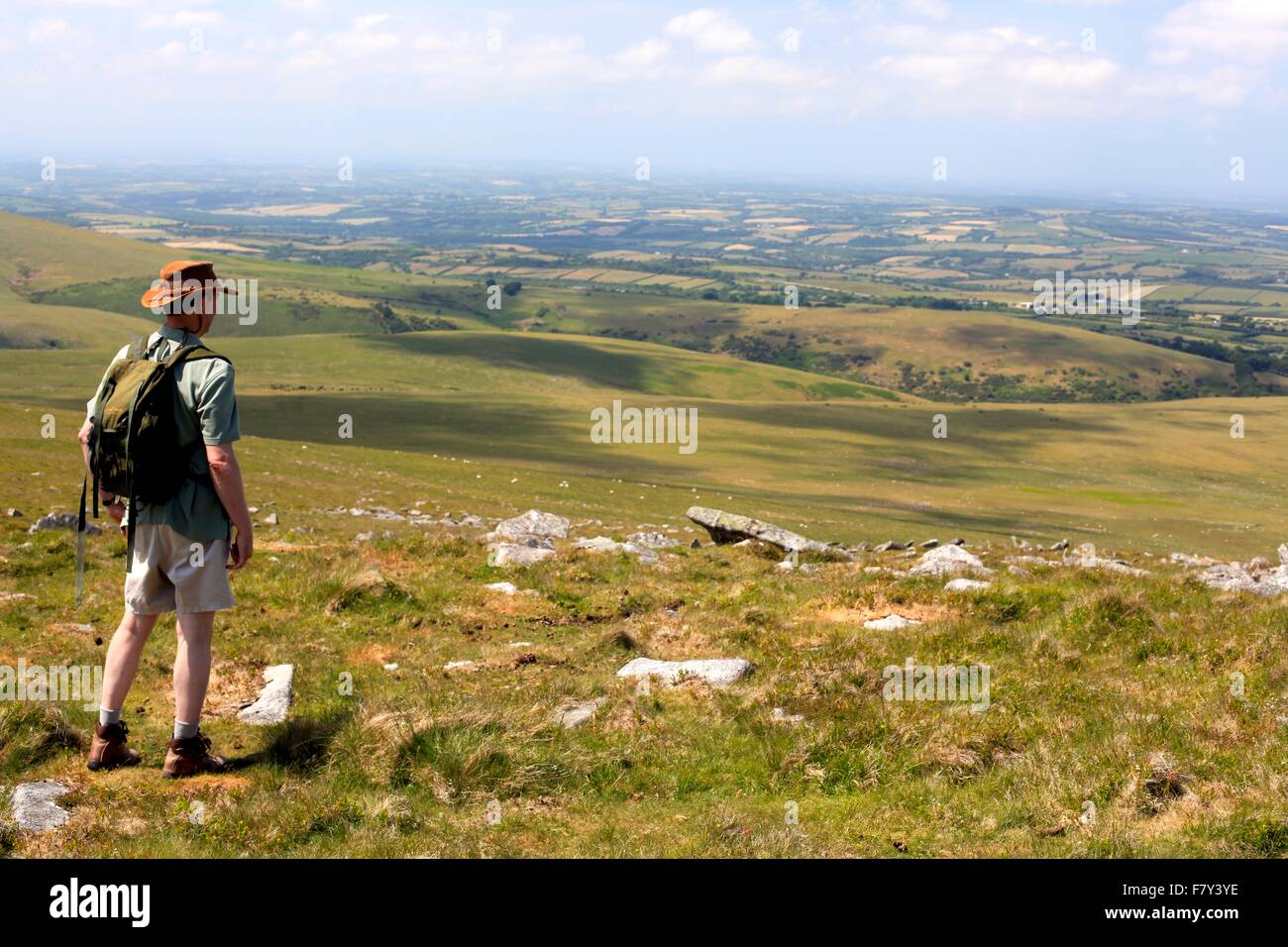 Walker auf Dartmoor bewundert den weiten Blick vor ihm Stockfoto