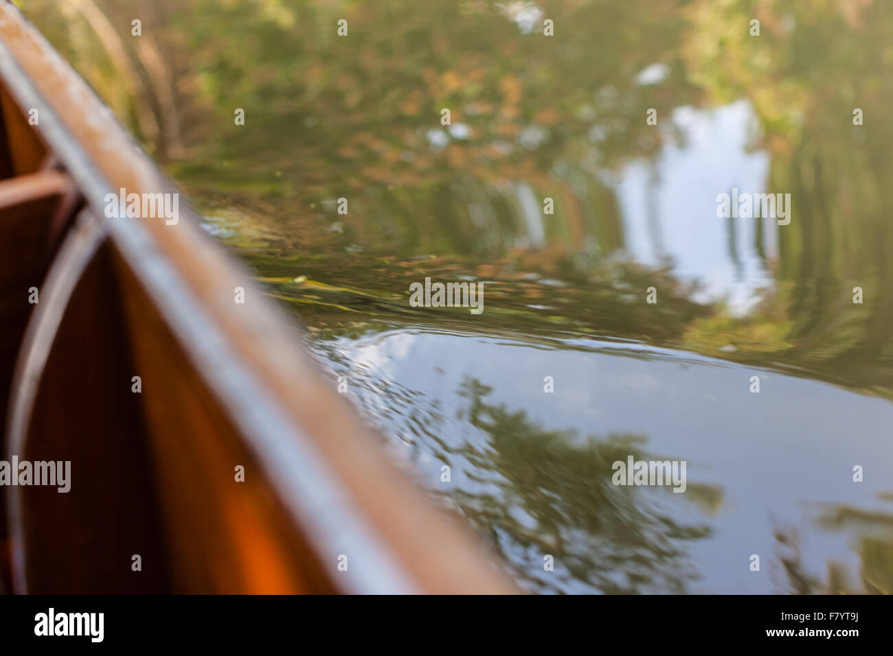 Wasser-Wellen auf der Seite eine kleine hölzerne Longtailboot Segeln in einem Lande Kanal in thailand Stockfoto