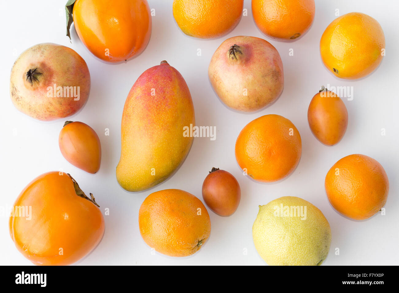 Viele frische orange Früchte auf weißem Hintergrund - Orangen, Zitrone, Mango, kaki Stockfoto