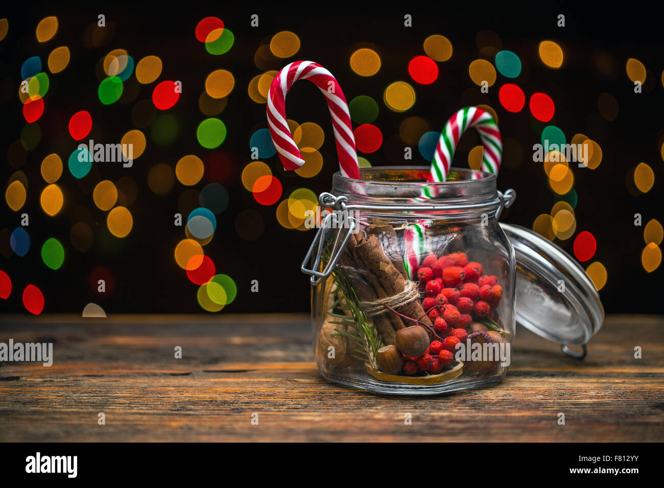 Glas mit verschiedenen Weihnachtsdekoration, Weihnachtsbeleuchtung auf Hintergrund Stockfoto