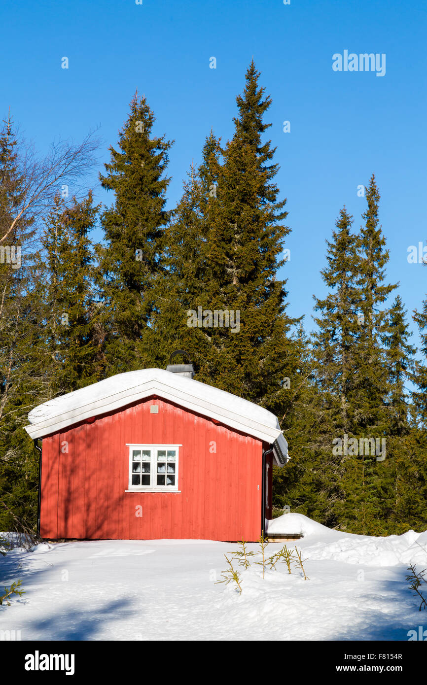 Typische rote norwegische Hütte, umgeben von Schnee im Wald nördlich von Oslo Stockfoto