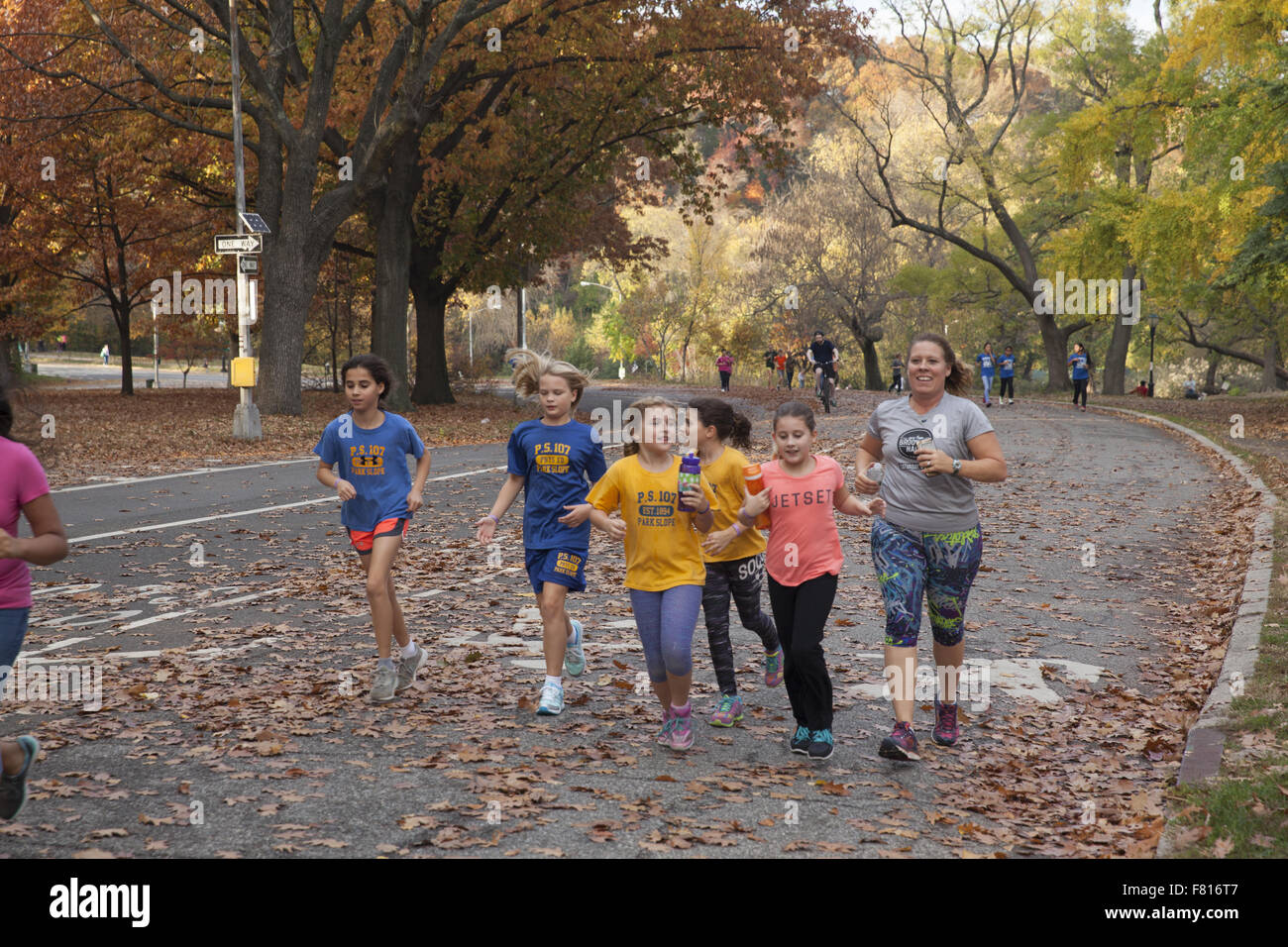 Grundschulkinder zusammen Joggen auf der Straße im Prospect Park in Brooklyn, New York. Stockfoto