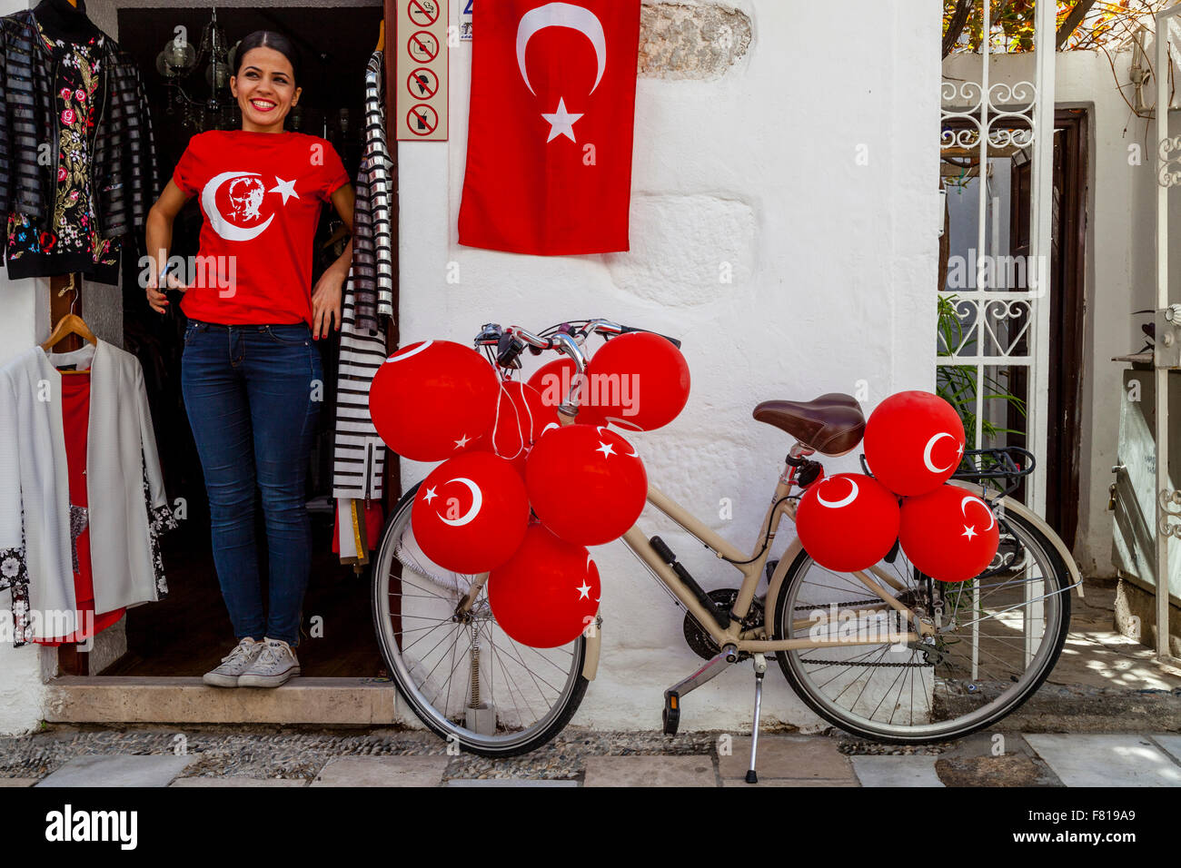 Eine junge Frau steht In der Tür eines Ladens In Bodrum Altstadt zeigt stolz die türkische Fahne, Bodrum, Türkei Stockfoto