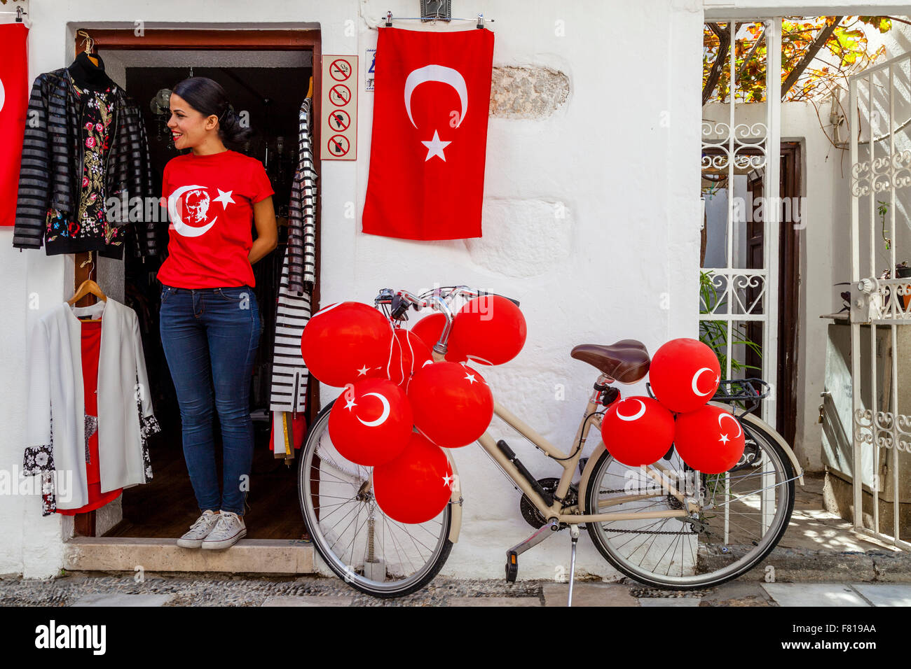 Eine junge Frau steht In der Tür eines Ladens In Bodrum Altstadt zeigt stolz die türkische Fahne, Bodrum, Türkei Stockfoto