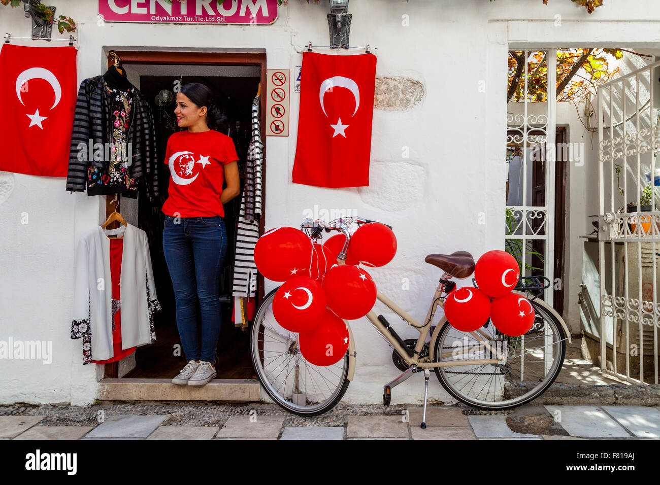 Eine junge Frau steht In der Tür eines Ladens In Bodrum Altstadt zeigt stolz die türkische Fahne, Bodrum, Türkei Stockfoto