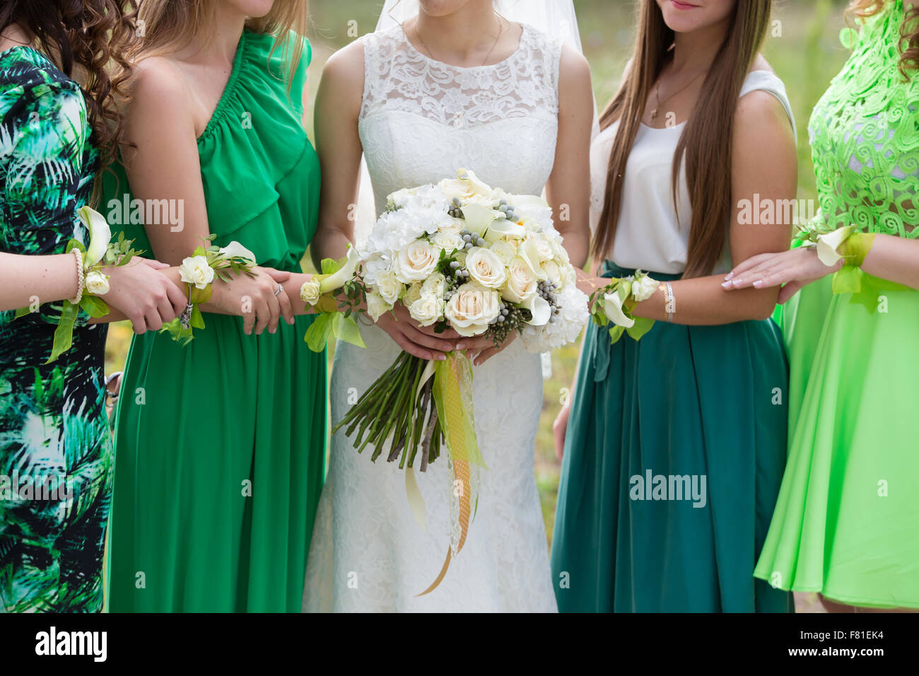 die Braut mit einem Blumenstrauß mit Freundinnen in grüne Kleider Stockfoto