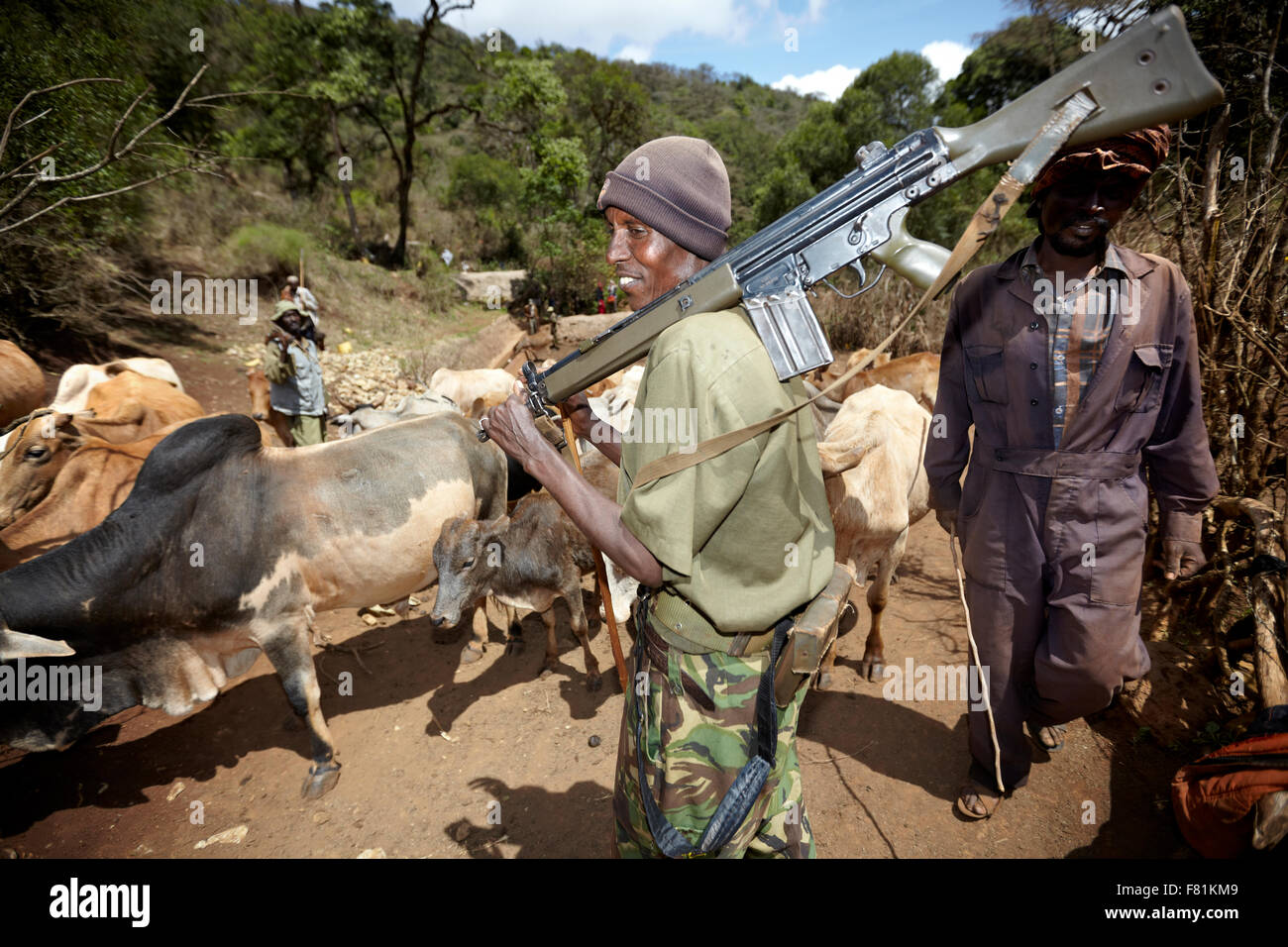 Bewaffneten Viehtreiber hüten Vieh Trog, singenden Brunnen in Marsabit im Norden Kenias. Stockfoto