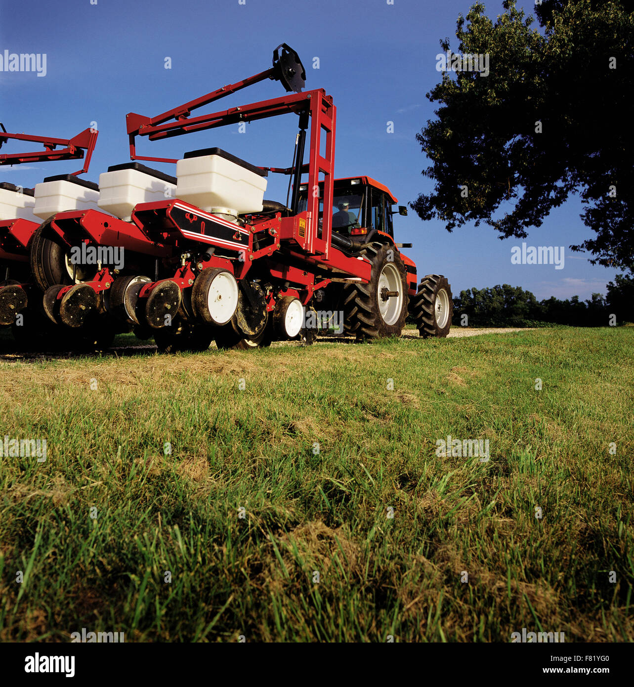 Eine moderne Landwirtschaft Sämaschine und Traktor bewegt sich zwischen Äckern. Stockfoto