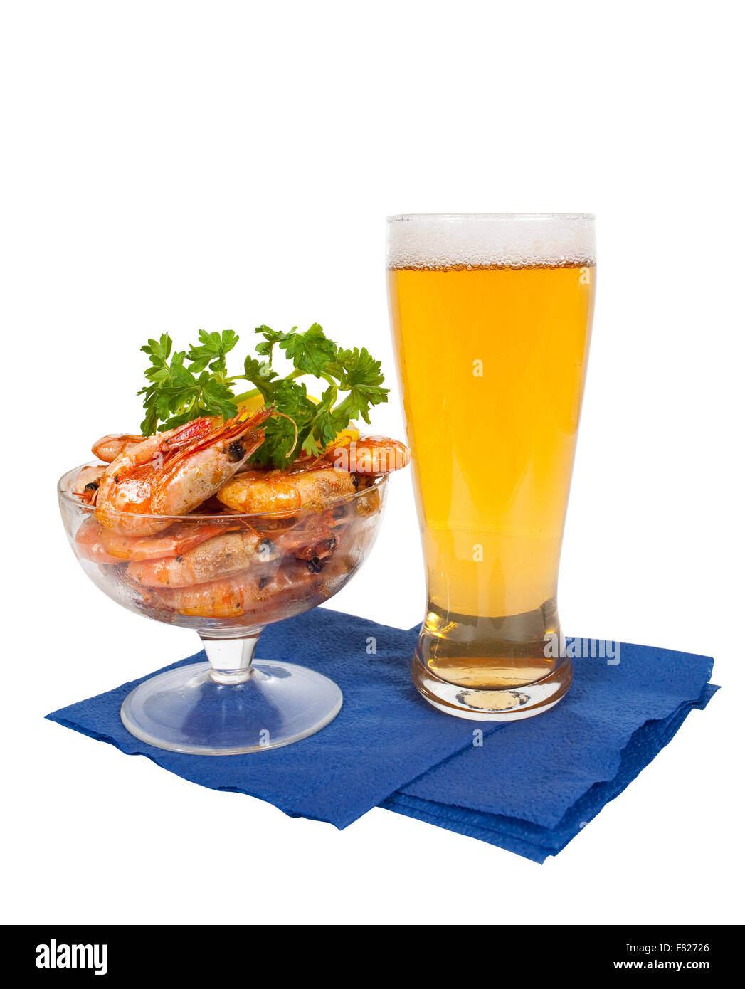 Bier im Glas und Teller mit Garnelen auf weißem Hintergrund Stockfoto