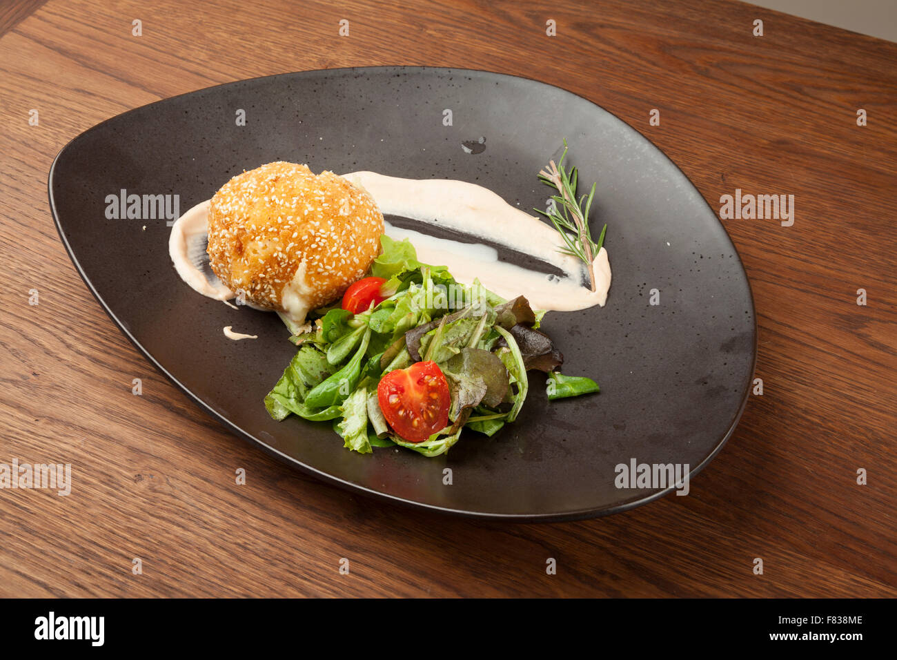 Gebratener Mozzarella mit Grillgemüse auf Holztisch Stockfoto