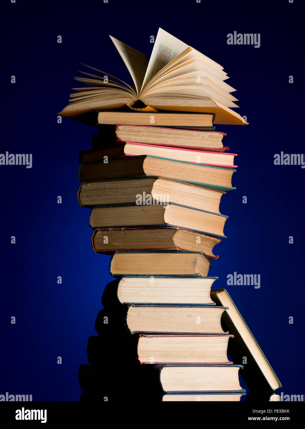 Stapel alter Bücher in eine Spirale drehen. Offenes Buch an die Spitze des Haufens. Büchersammlung. Lesen Sie, Bildung Metapher. Stockfoto