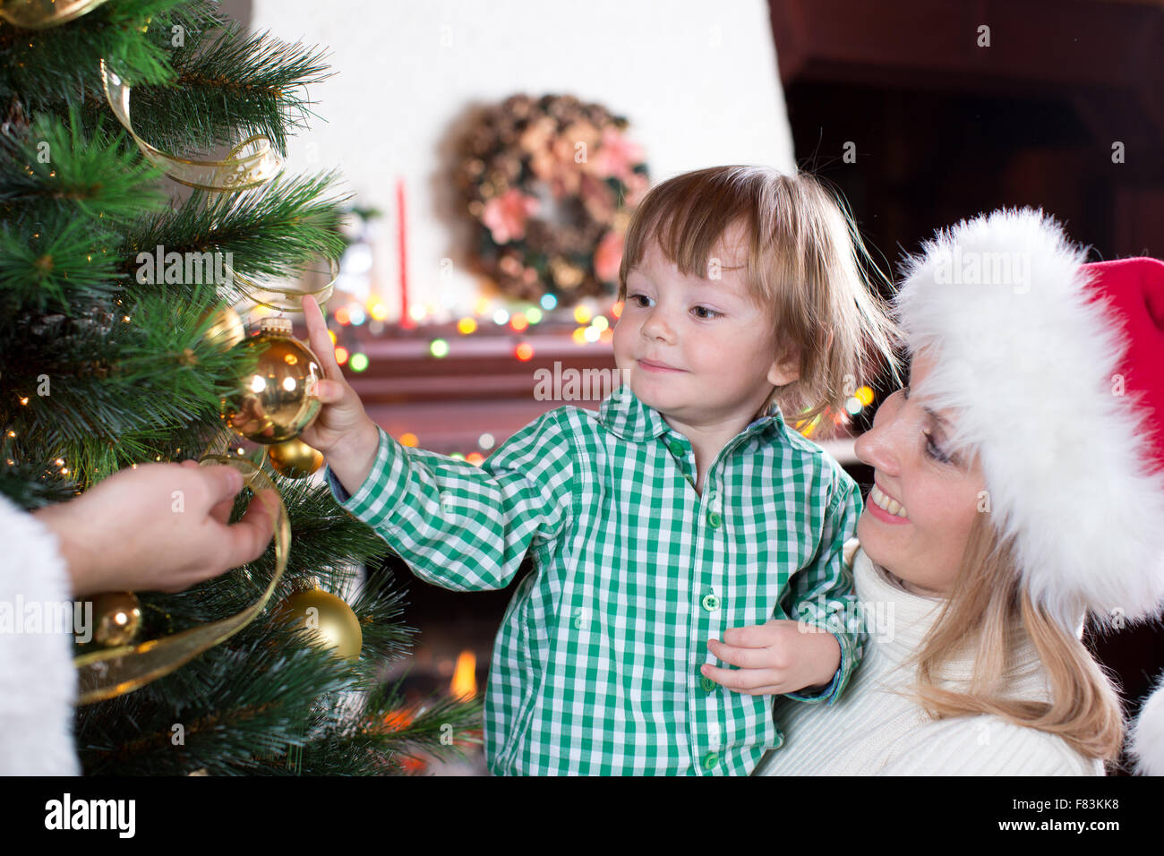 Kind Junge hilft Mutter und Vater, Familie Weihnachtsbaum schmücken Stockfoto