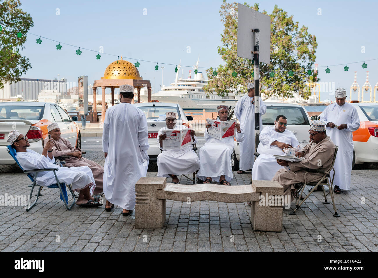 Omanische Taxifahrer lesen Zeitungen an der Promenade von Mutrah in Muscat, der Hauptstadt des Sultanats Oman. Stockfoto