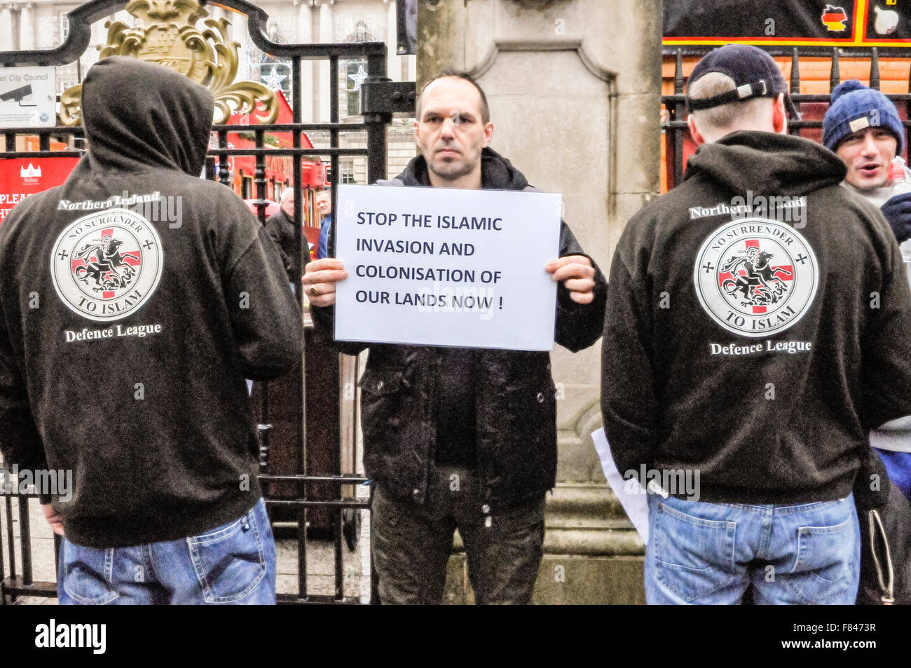 Belfast, Nordirland. 5. Dezember 2015 - ein Mann hält ein Plakat mit der Meldung "Stop der islamischen Invasion und Besiedlung unseres Landes jetzt!" während die beiden Männer tragen Hoodies mit dem Slogan "Northern Ireland Defence League.  Kein Verzicht auf den Islam ". Bildnachweis: Stephen Barnes/Alamy Live-Nachrichten Stockfoto
