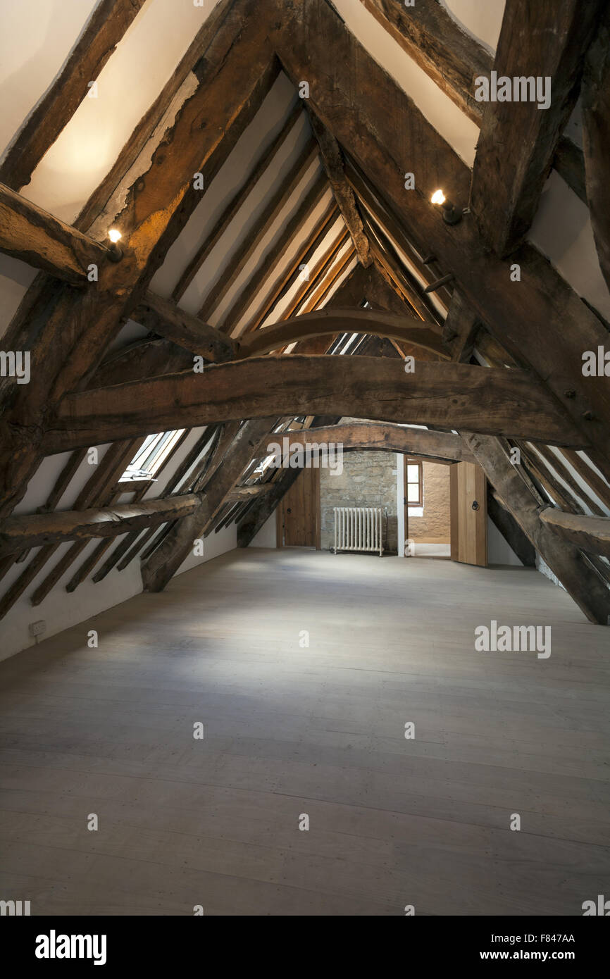 Eine unmöblierte Zimmer im Dachgeschoss mit sichtbaren Balken in einem Haus. Stockfoto