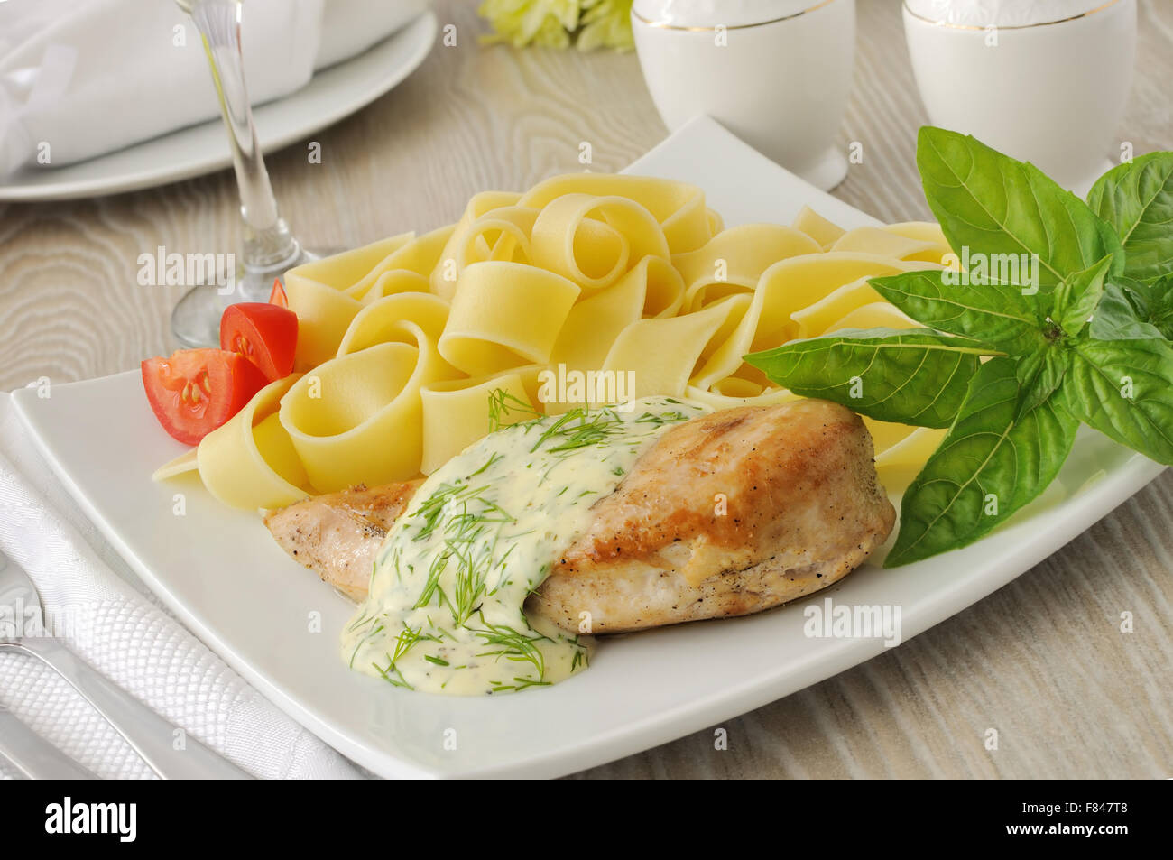 Italienische Pasta - Pappardelle mit Huhn in Sahne-Sauce und Kirschtomaten Stockfoto