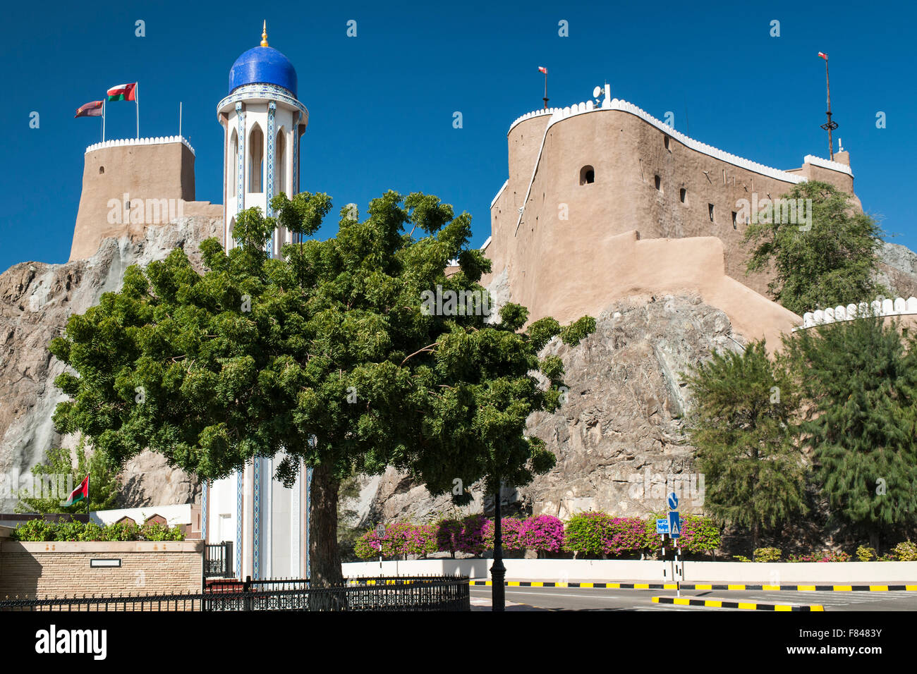 Al Mirani Fort und das Minarett der Al Khor Mosque in alten Muscat, der Hauptstadt des Sultanats Oman. Stockfoto