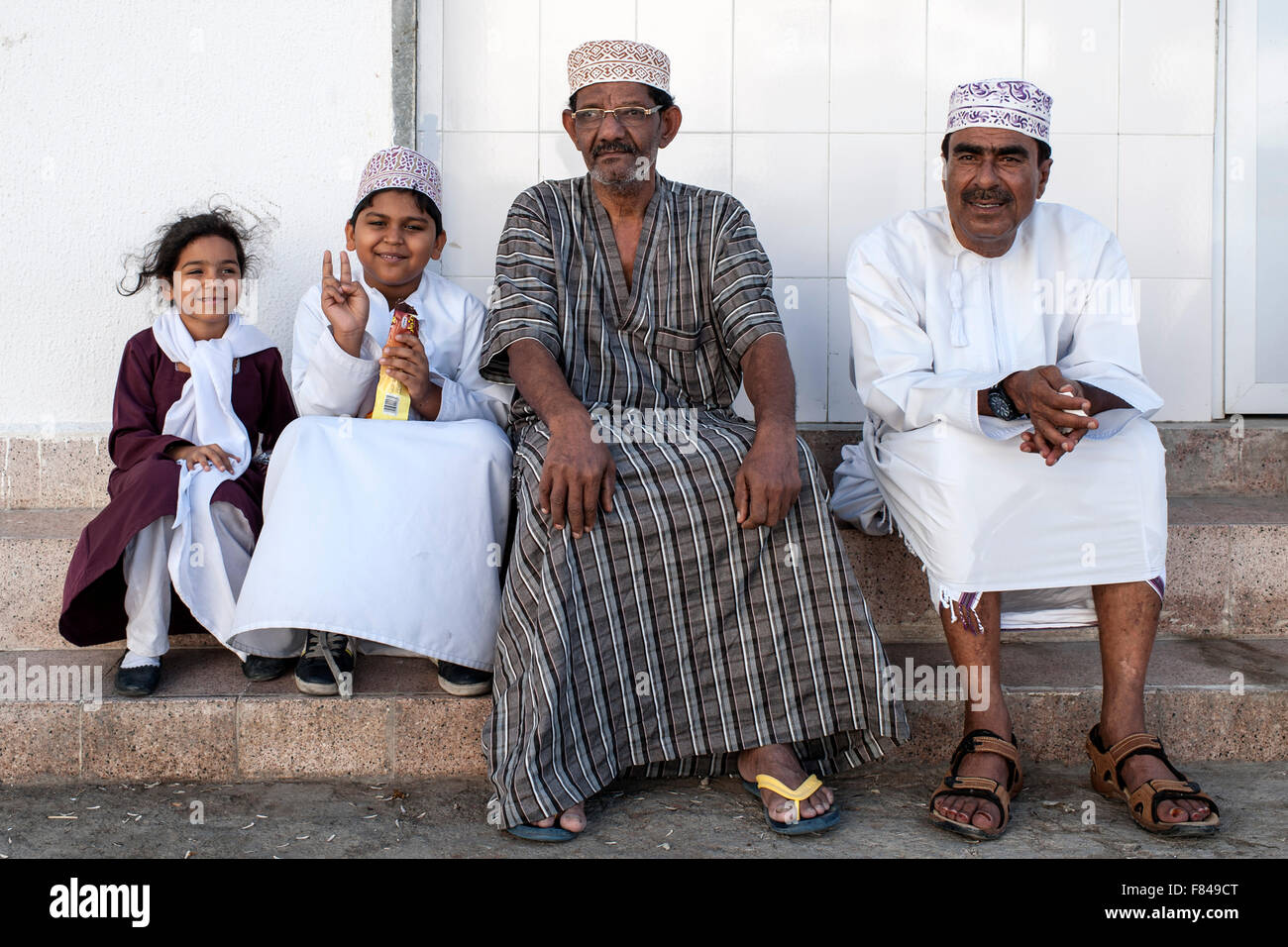 Omanische Männer und Kinder sitzen in alten Muscat, der Hauptstadt des Sultanats Oman. Stockfoto