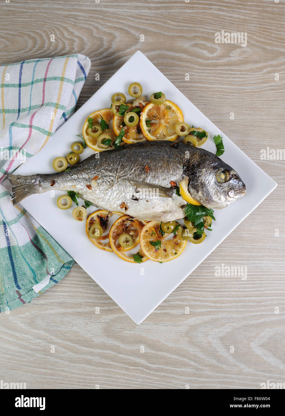 Gebackener Fisch (Dorado) mit Zitrone und Oliven Stockfoto