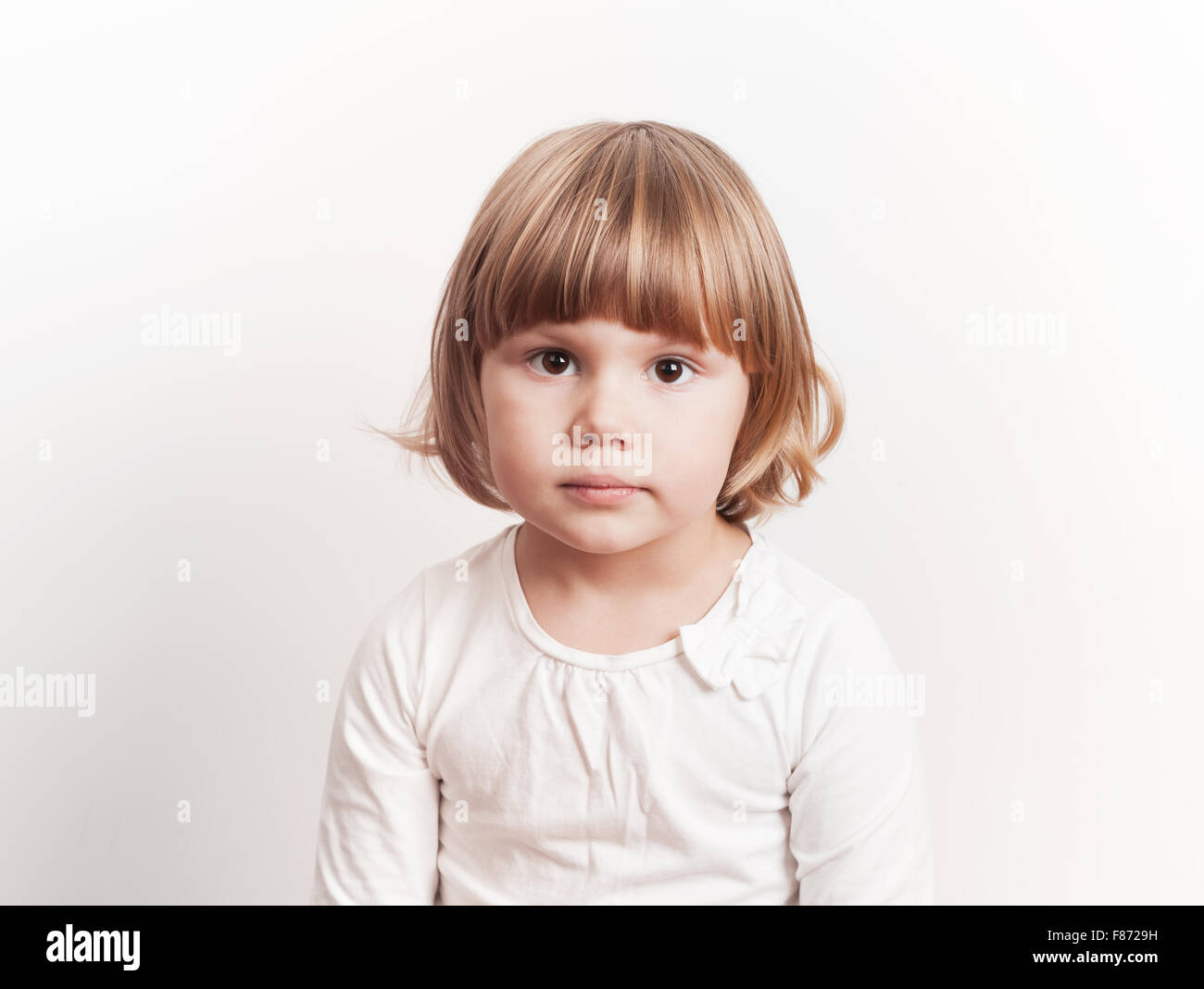 Niedliche kleine blonde kaukasische Mädchen auf weißem Hintergrund, Studio-Porträt Stockfoto