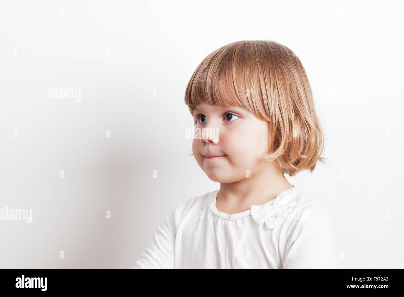 Kleine blonde kaukasische Mädchen über weiße Wand Hintergrund, Studioportrait Stockfoto