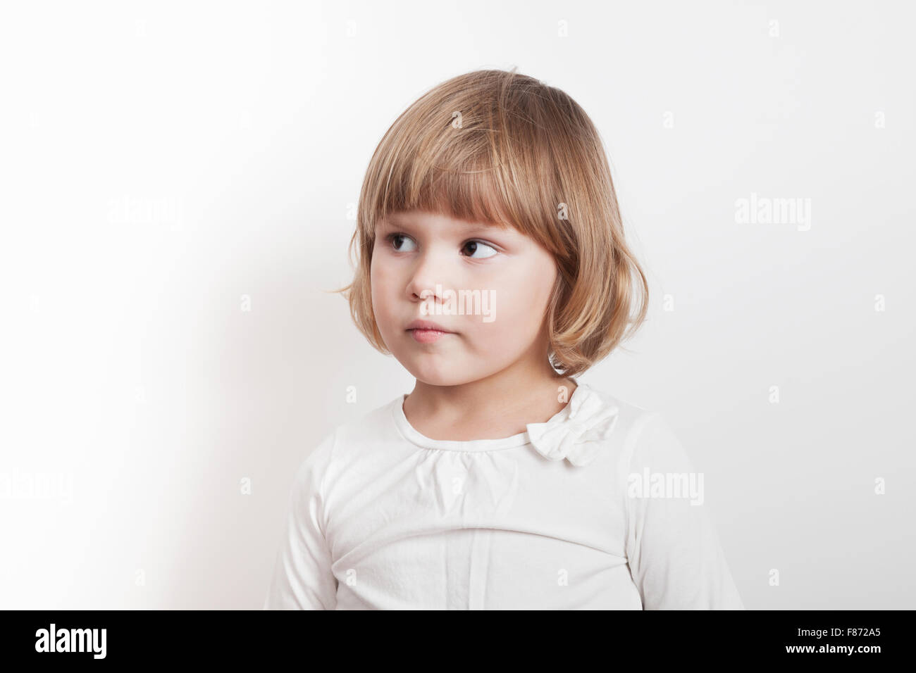 Kleine blonde kaukasische Mädchen auf weißem Hintergrund, Studioportrait Stockfoto