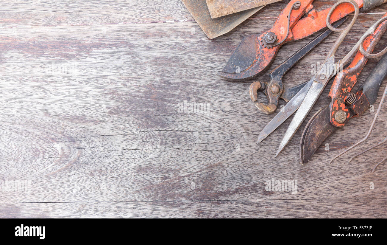 Alte rostige Werkzeuge - Vintage Handarbeit auf hölzernen Hintergrund mit Textfreiraum Stockfoto