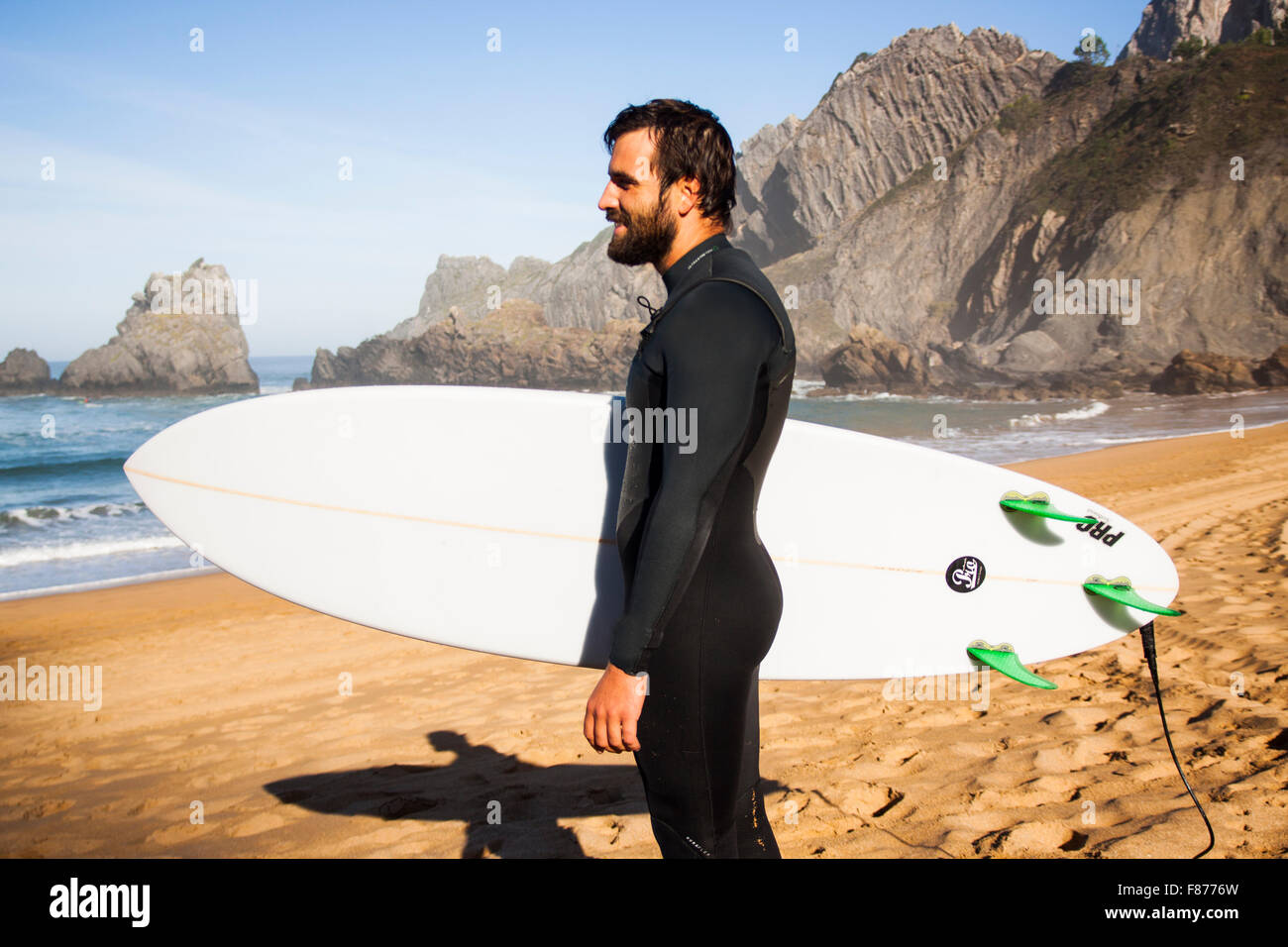 Surfer mit seinem Brett auf den Strand, das Meer zu beobachten Stockfoto