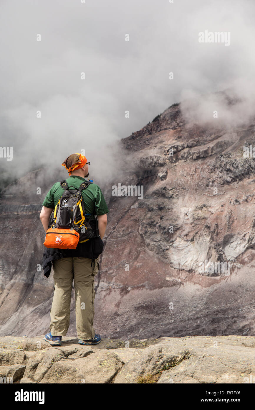 Mann starrte auf die malerische Aussicht auf die tief liegenden Wolken Überrollen der Nisqually Glacier in Mount Rainier Nationalpark Stockfoto