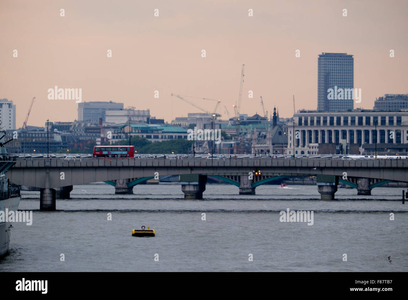 Ein Doppeldecker-Bus überquert man die vielen Brücken über den Fluss Themse in London, England Stockfoto