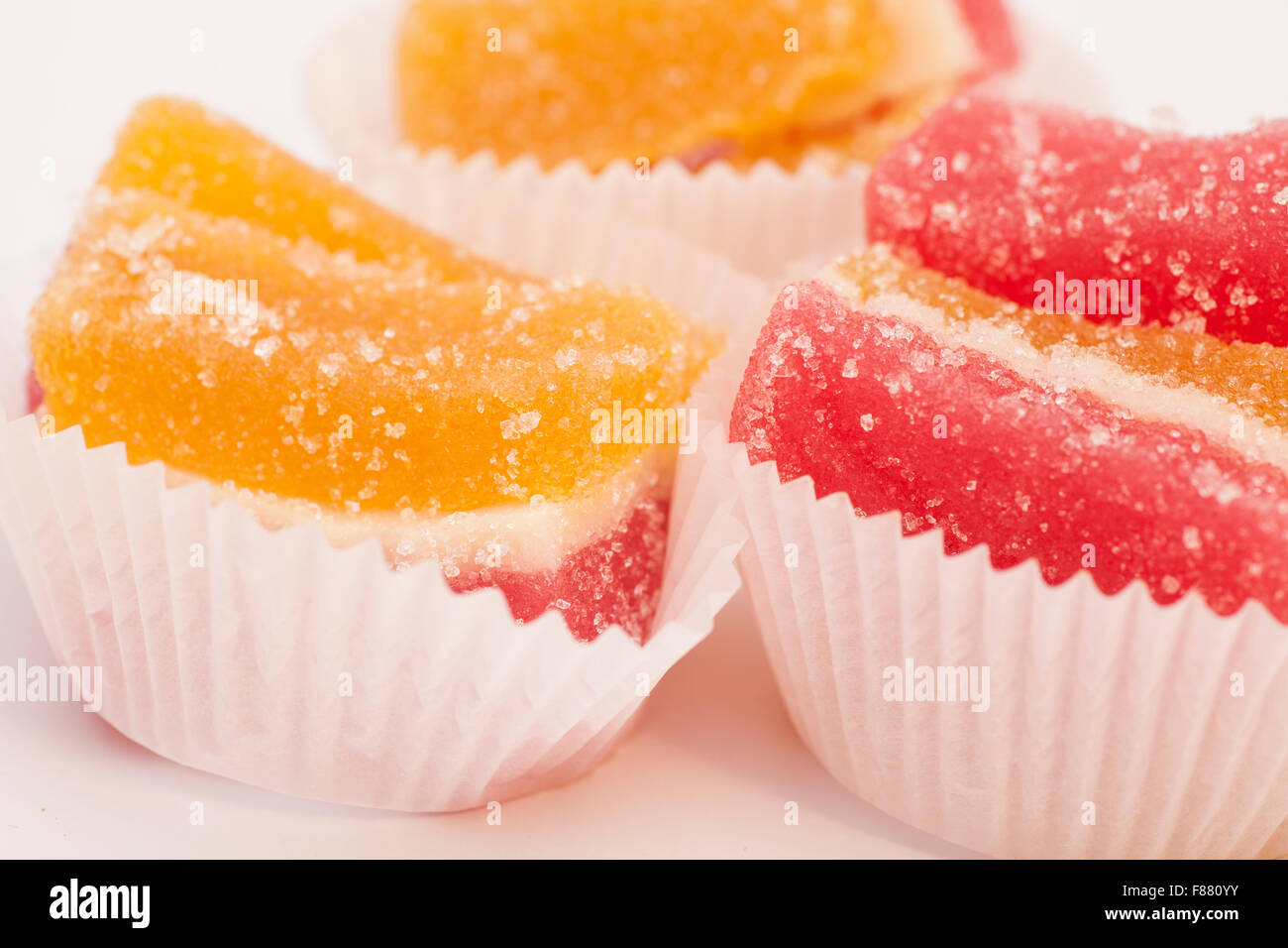 Gelee-Bonbons in weißen Tasse Kuchen Fällen isoliert auf weiss Stockfoto