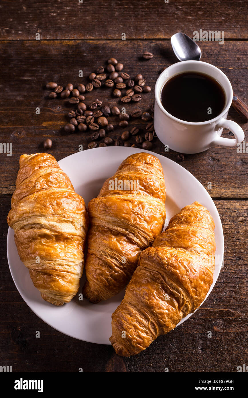 Kaffee und Croissants zum Frühstück am rustikalen Holztisch Stockfoto