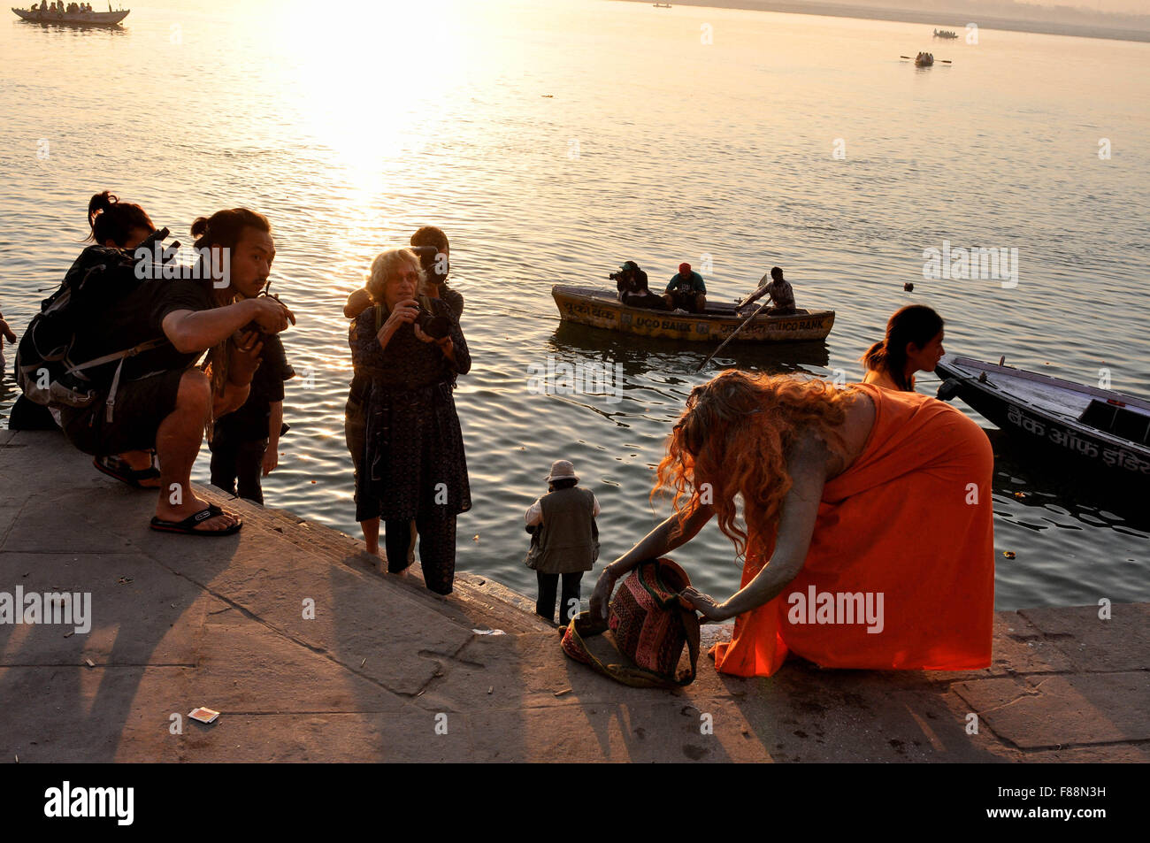 Auf Kumbh, ein ausländischer Anhänger nach der Einnahme Bad im heiligen Fluss Ganges und einige Touristen am Ghat in Varanasi, Uttar Pradesh, Indien. Stockfoto