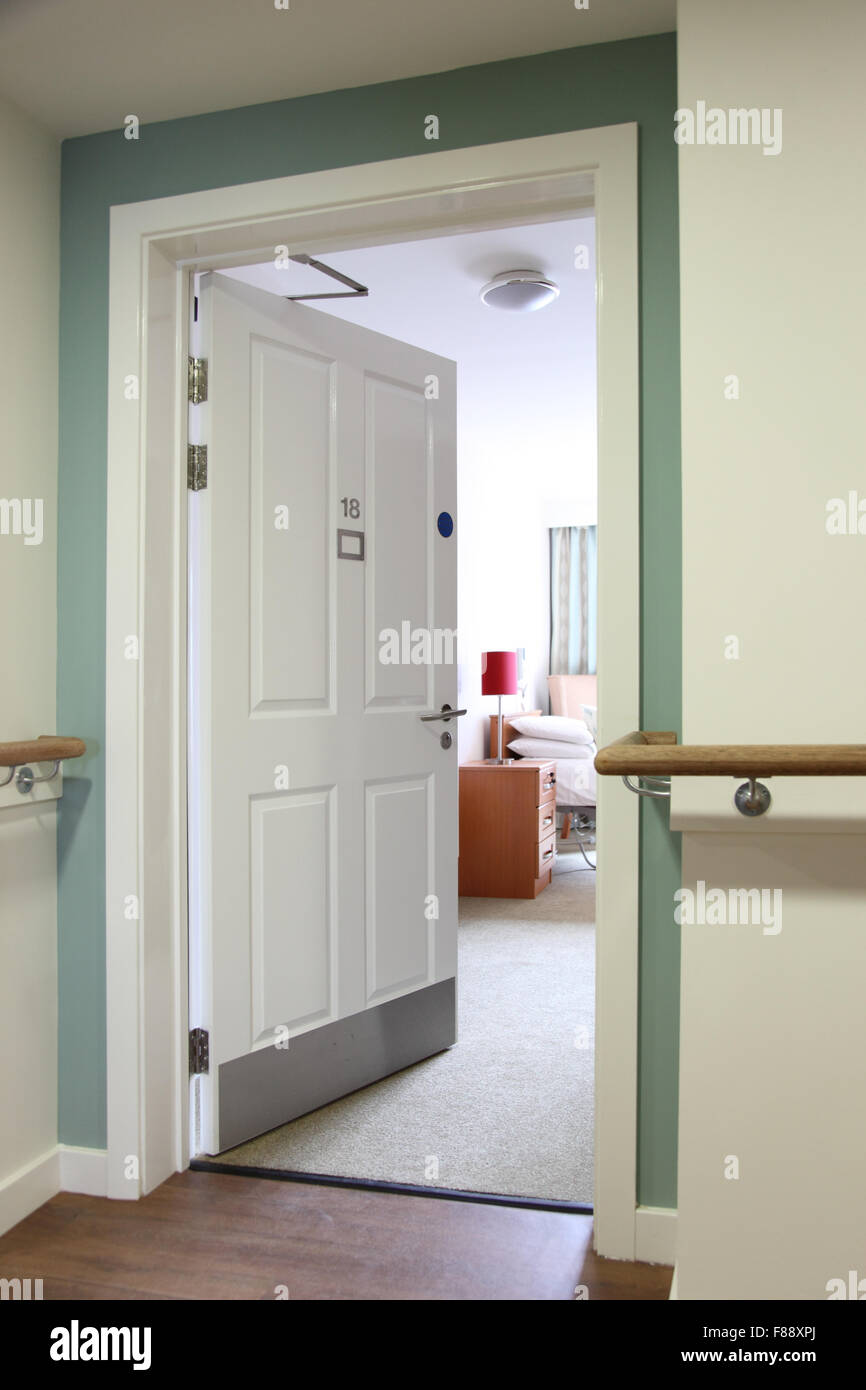 Eingangstür eines Bewohners Zimmer in einem neuen, UK Care Home. Zeigt Brandschutztür Zubehör und Support Schienen an der Wand Stockfoto