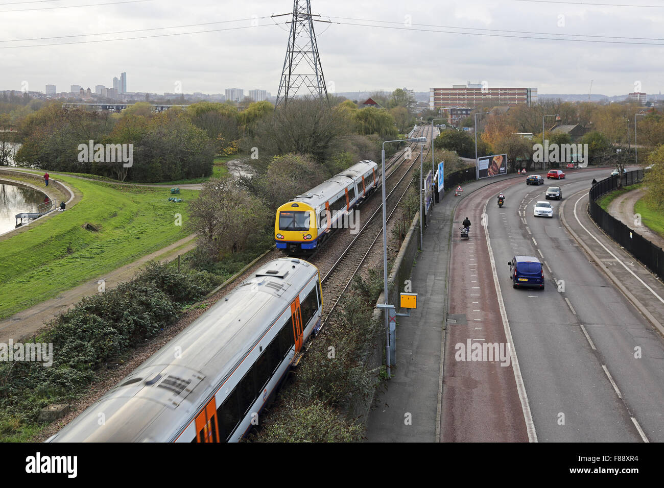 Ansicht von London Overground Eisenbahnlinie im Norden Londons zeigt zwei Züge und der angrenzenden Straße mit Bus, Bahn und Geschwindigkeit Kamera Stockfoto