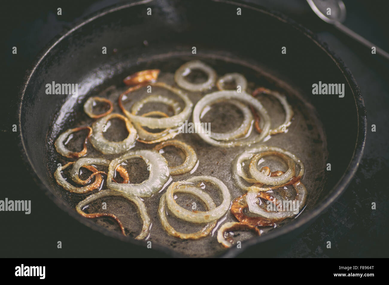 Ringe in weiß schwarz Pfanne Zwiebel anbraten in Öl Stockfoto