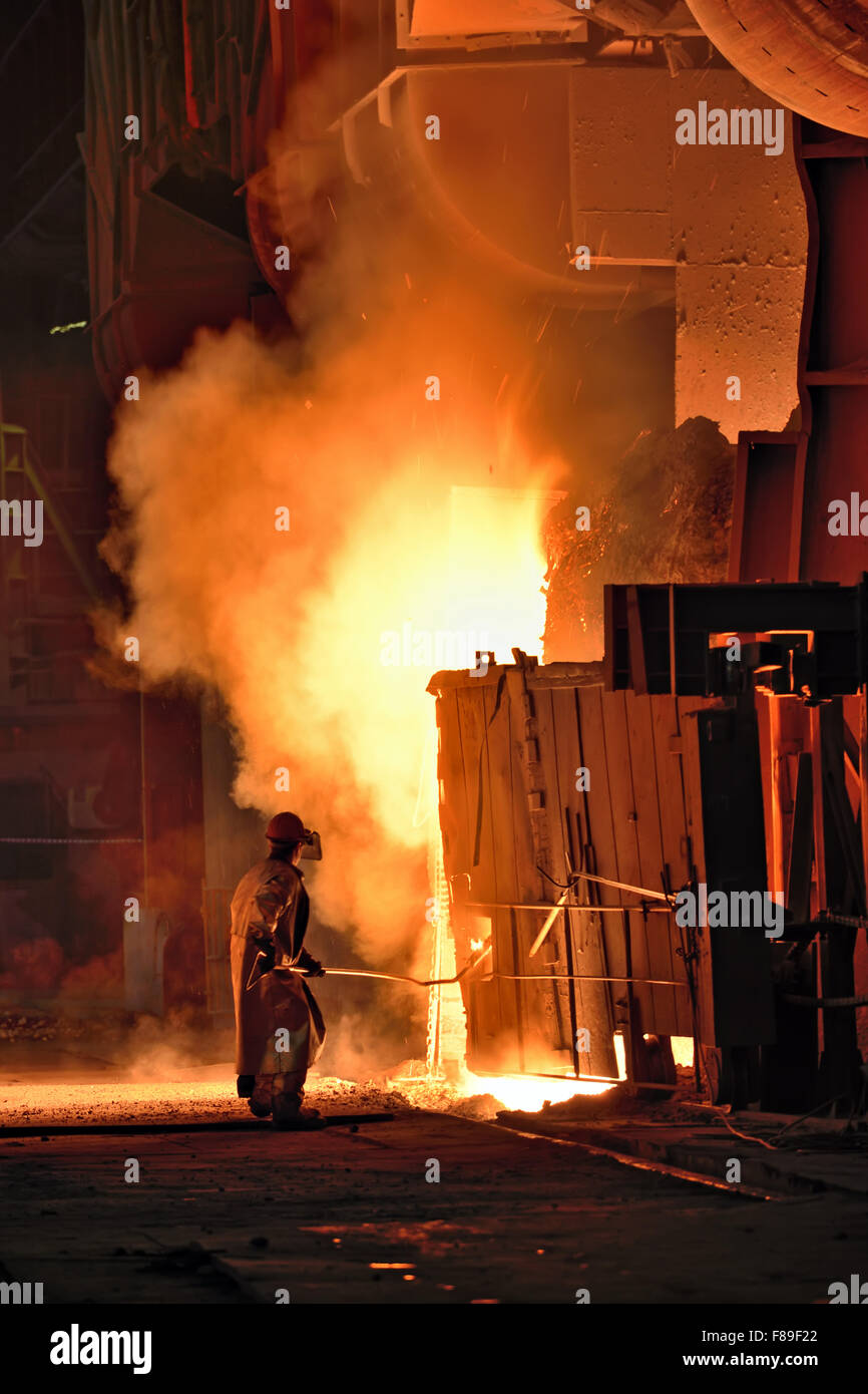 Arbeiter in einer Stahlprobe machen Fabrik Entnahme aus dem Ofen Stockfoto