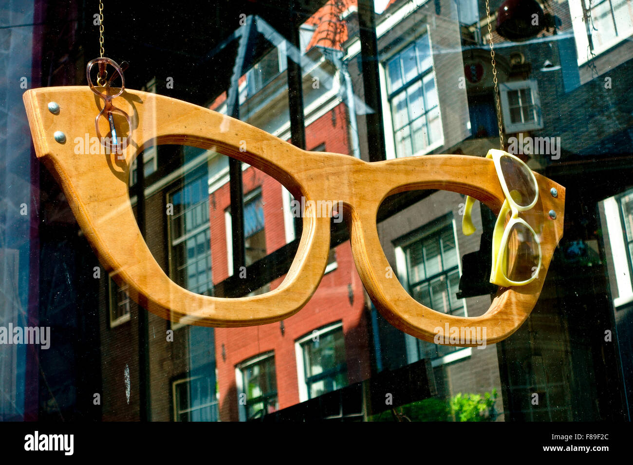 Nahaufnahme von oversize, riesig, Big eye Brille Frame als Optiker anmelden Werbung hängen im Shop angezeigt. Amsterdam, Niederlande, Europa Stockfoto