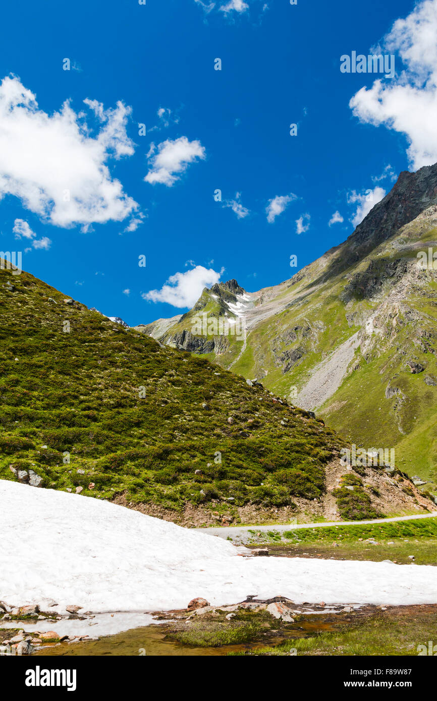 Ein Schneefeld in grüne Berglandschaft im Pitztal in Österreich Stockfoto