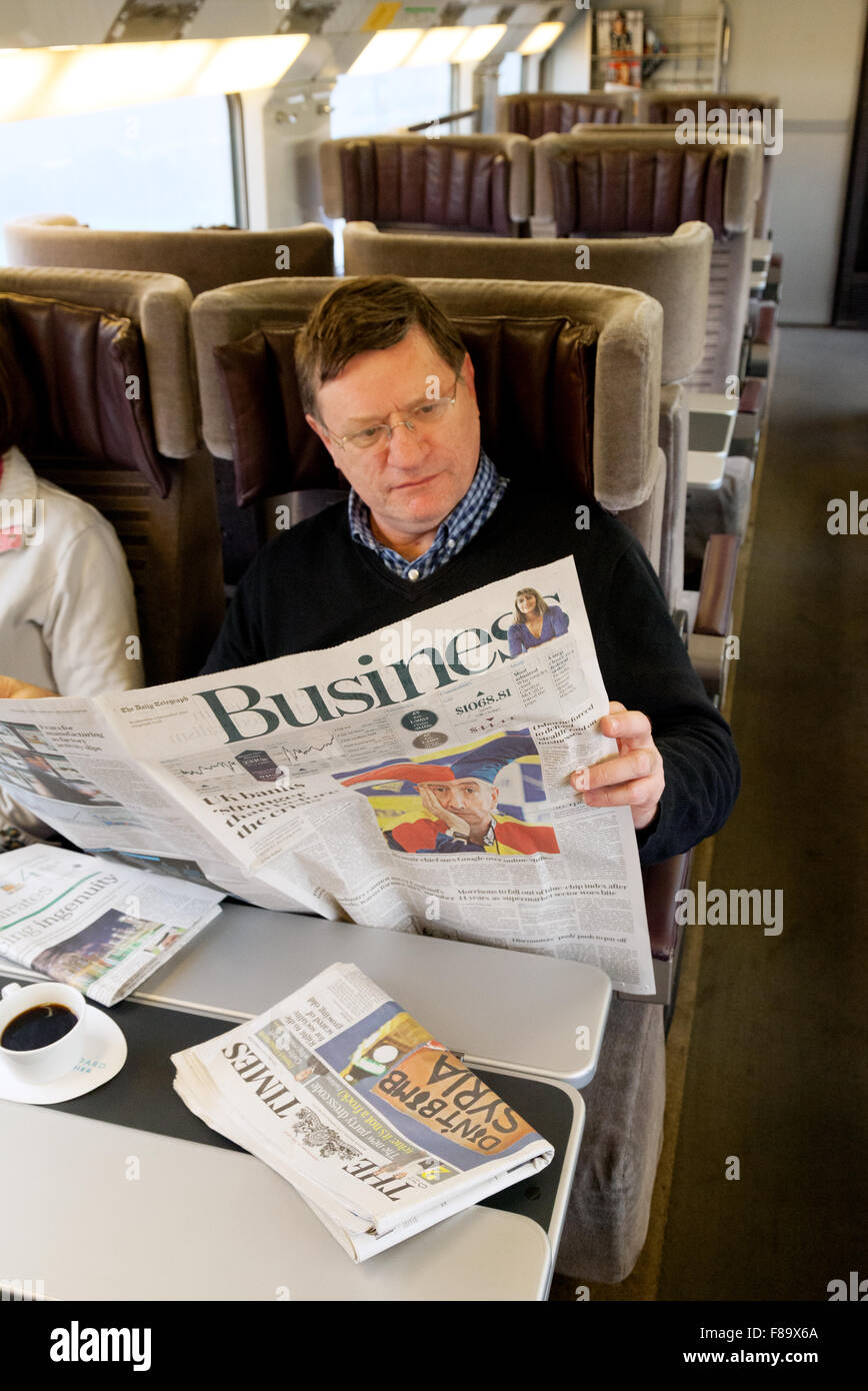 Ein Geschäftsmann, der den Geschäftsbereich einer Zeitung liest; Innenraum, Eurostar-Zug von St. Pancras nach Paris. Geschäftsreisen Europa Stockfoto